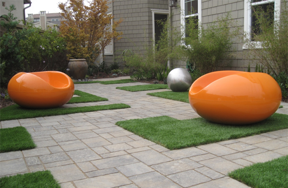 A CA modern garden path with pavers, synthetic turf, modern outdoor furniture, garden balls, and bamboo.