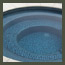 A blue tiled spa sits in modern landscape with succulent dry garden, smooth stucco bench, and curved firepit